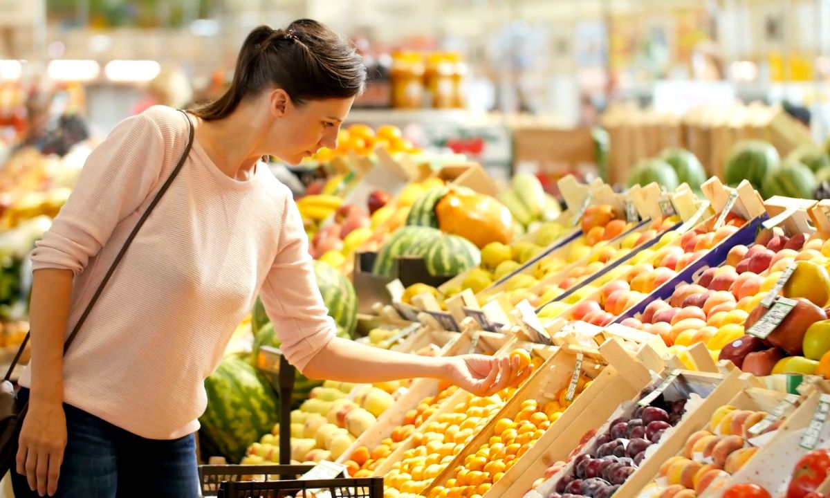 žena u supermarketu bira voće